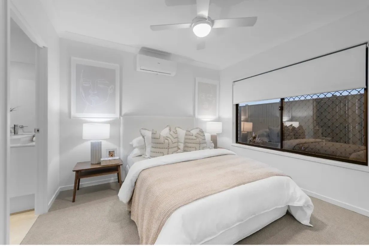 Carpeted master bedroom with queen bed, ceiling fan, air conditioner and ensuite access