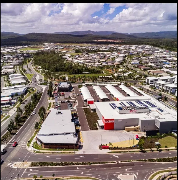 Aerial view of a Yarrabilba shopping centre with a Coles supermarket, carpark and surrounding new housing