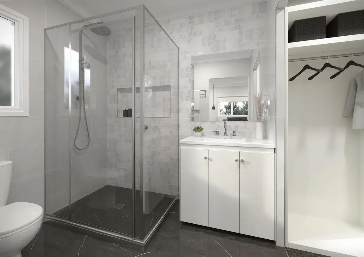 Frameless glass shower, dark tiled floor and white vanity in an ensuite with walk-in robe